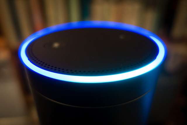 Amazon's Echo smart speaker with its blue light ring illuminated.