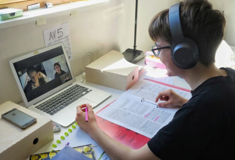 A student studying on his laptop with two friends after classes were cancelled.